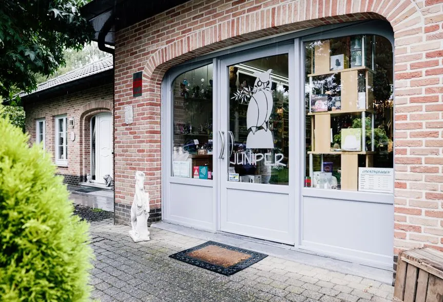 Voorgevel van de winkel Juniper met de glazen deuren en het uilenlogo